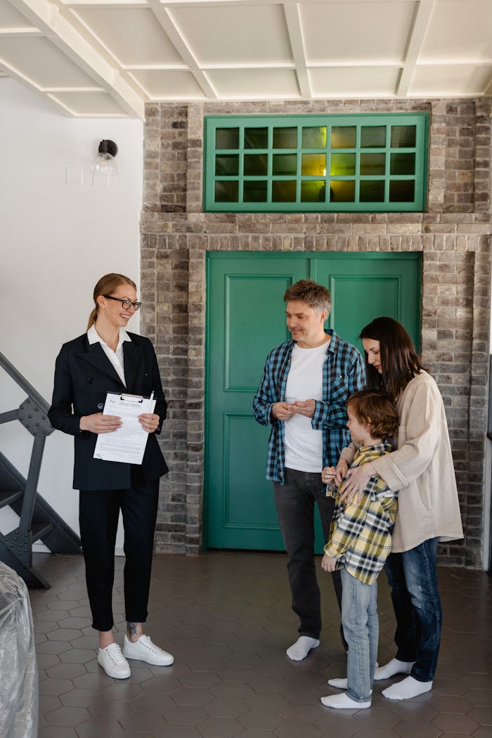 Real estate agent presenting a home to a family with young children indoors.